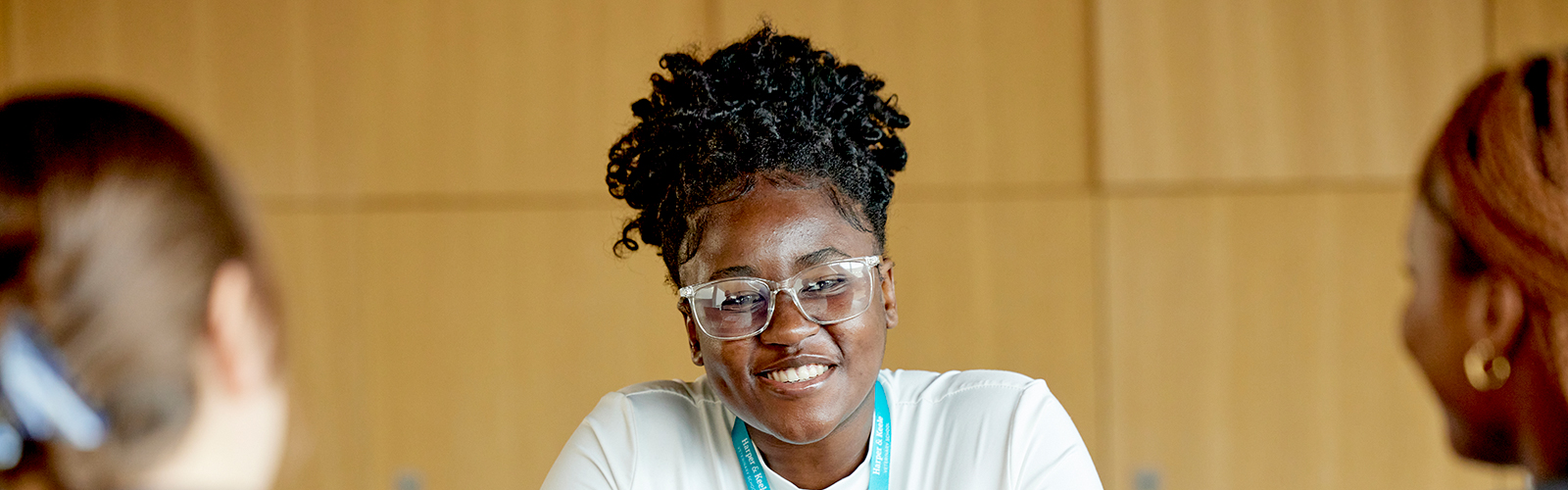 Three females are talking in a room.