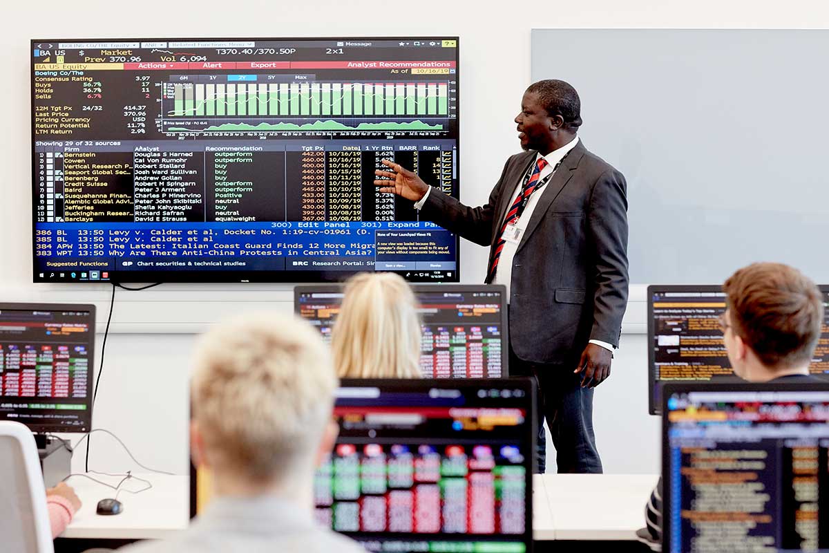 A tutor pointing at a screen of data