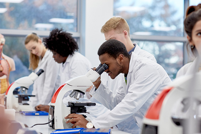 A student looking through a microscope